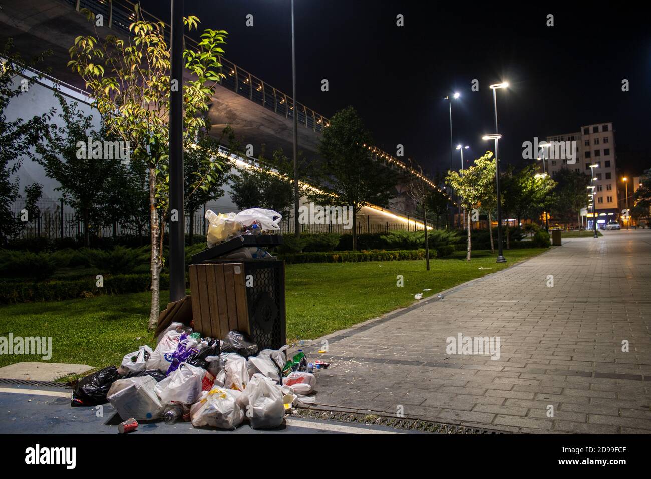 Ein wunderschöner Park und die Haliç Metro Bridge hinter einer bösen Mülltonne. Umweltauswirkungen des menschlichen Lebens. Stockfoto