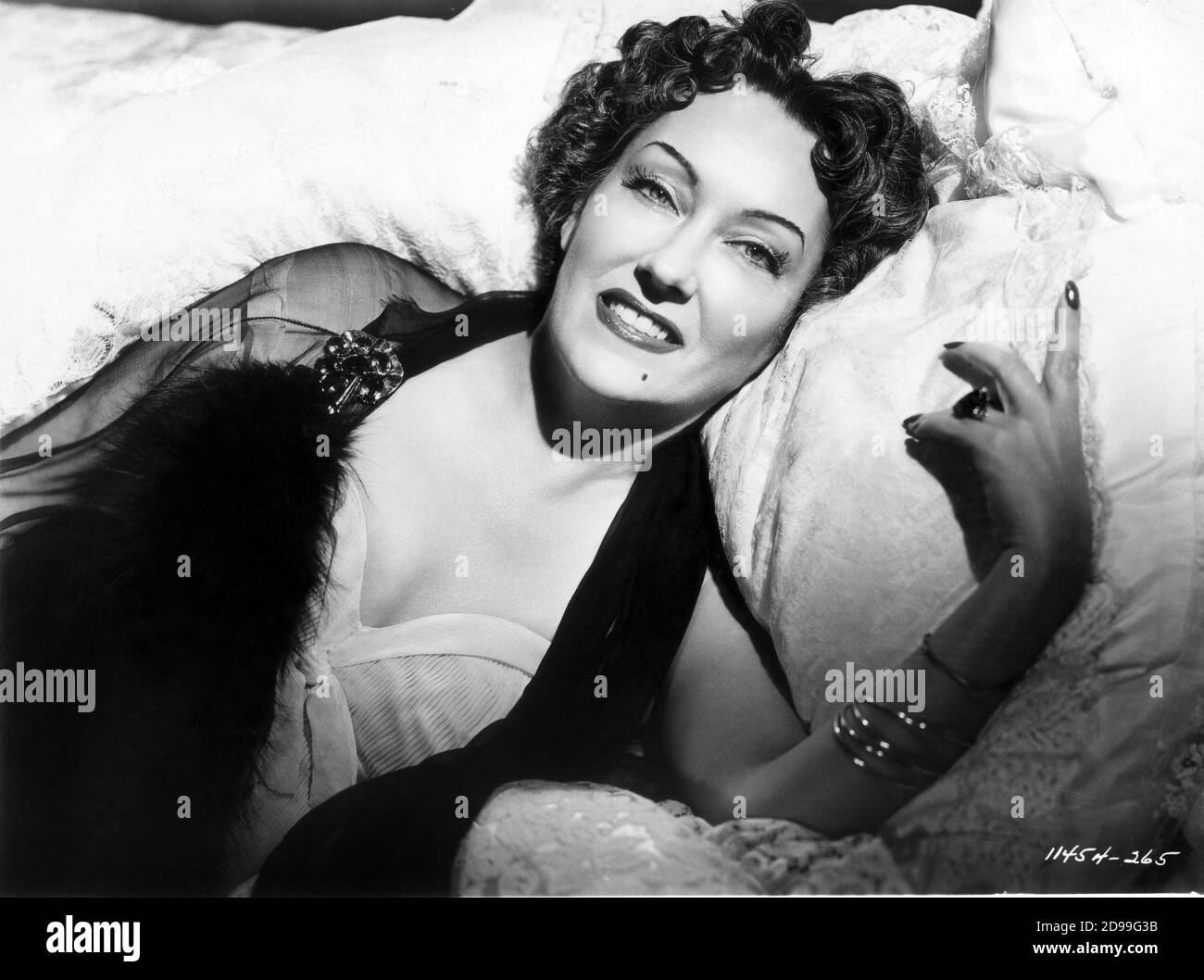 1950 , USA : die gefeierte Filmschauspielerin GLORIA SWANSON ( 1898 - 1983 ) als Norma Desmond in SUNSET BOULEVARD ( 1950 - VIALE DEL TRAMONTO ) von Billy Wilder , Paramount Pictures . - FILM - KINO - FILM - Kette - scollatura - decolleté - Lächeln - sorriso - Bett - letto - neo - Maulwurf ---- Archivio GBB Stockfoto