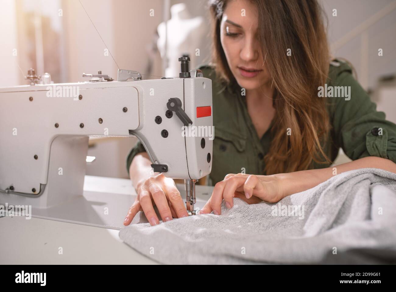 Seamstress arbeitet an neuen Kleidungsstücken, die vom Internet-Kunden bestellt werden Stockfoto
