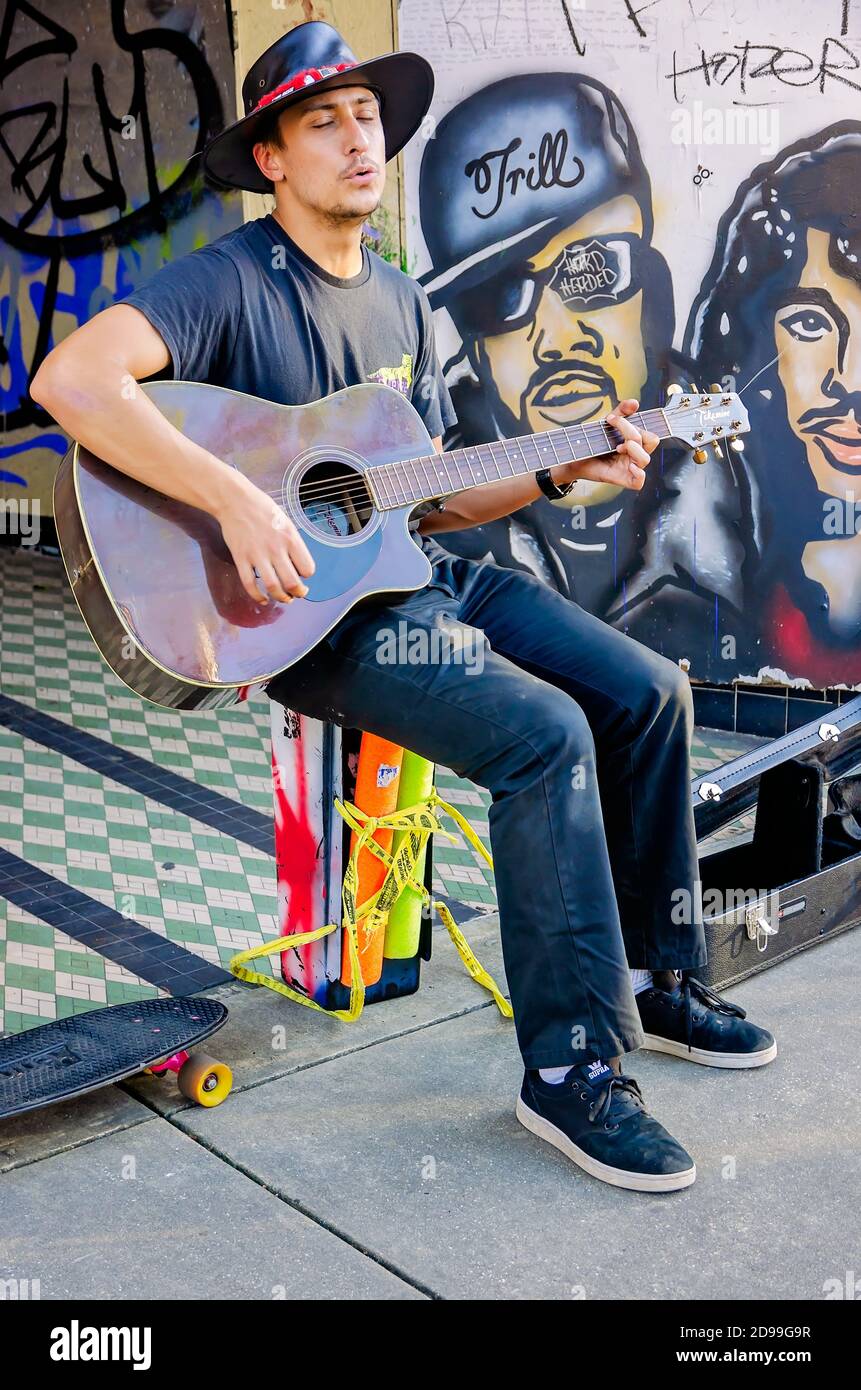 Ein Busker tritt auf Dauphin Street umgeben von Black Lives Matter Graffiti, Oktober 31, 2020, in Mobile, Alabama. Stockfoto
