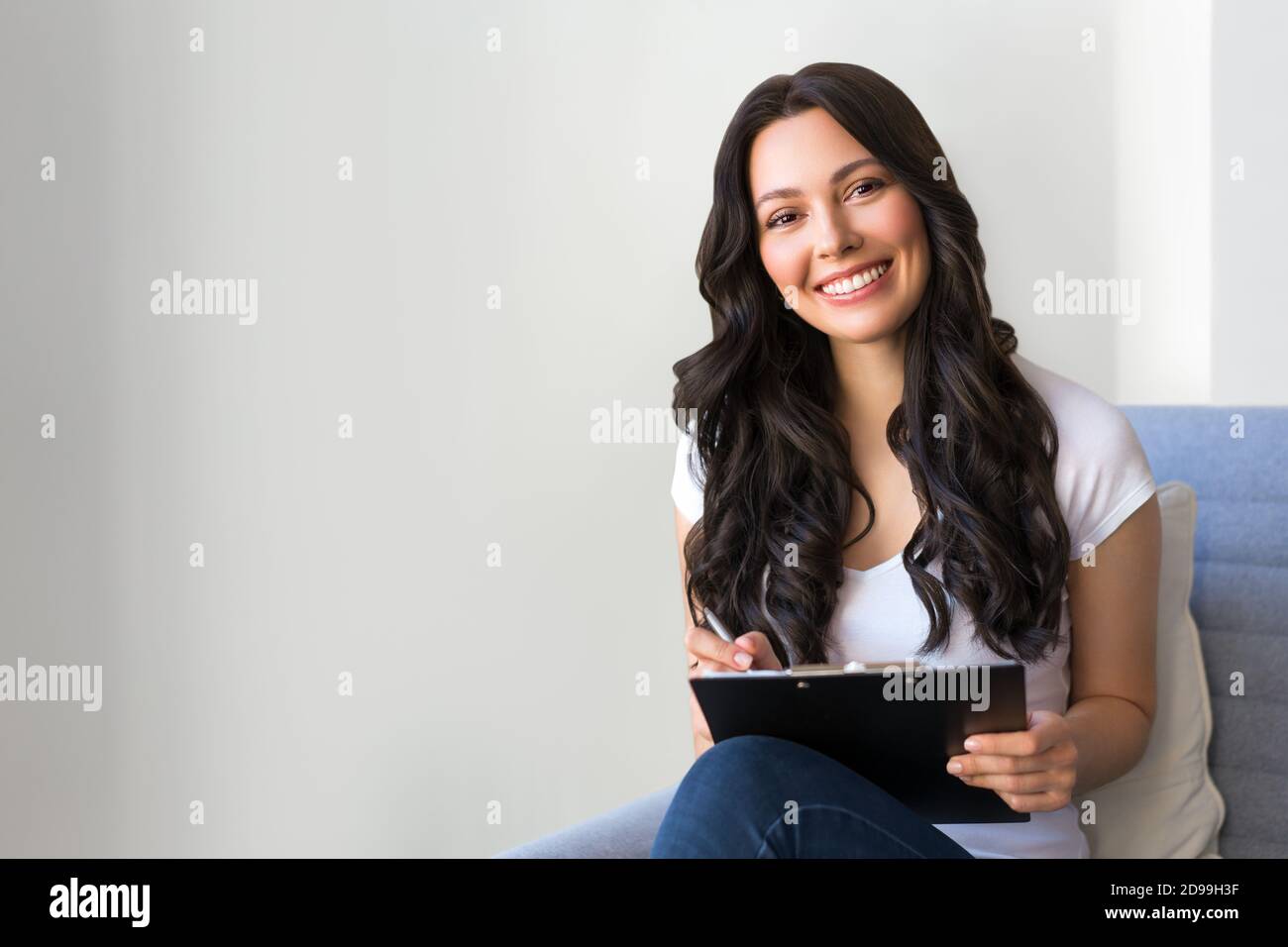 Porträt einer jungen Frau im Büro. Frau schreibt Daten in den Fragebogen Stockfoto