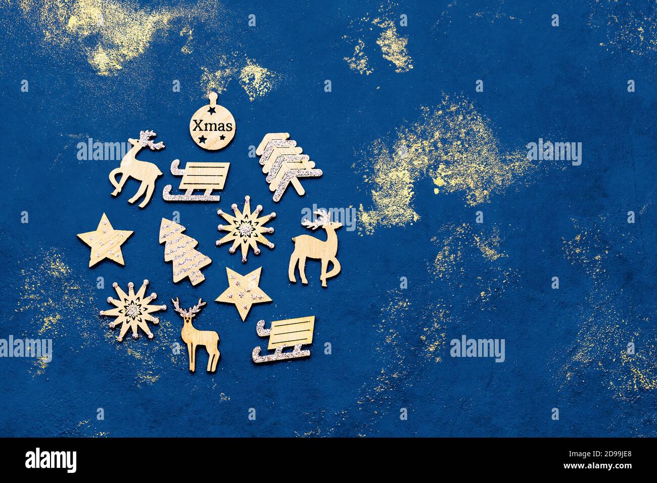 Blauer weihnachtlicher Hintergrund. Weihnachtliche Holzverzierungen in Form einer Weihnachtskugel auf blauem Hintergrund. Draufsicht, Kopierbereich. Farbe des Stockfoto