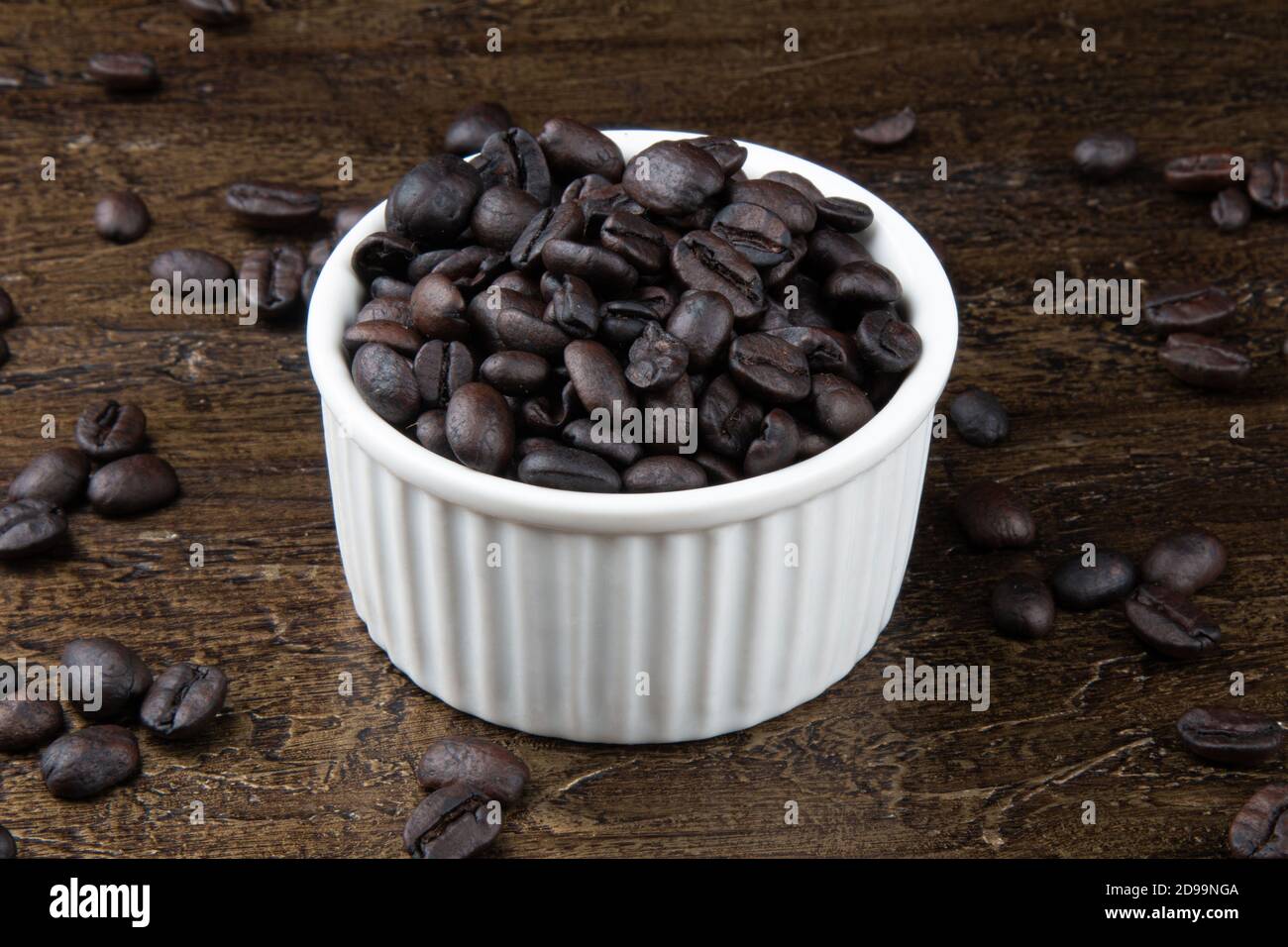 Geröstete Kaffeebohnen in weißer Schüssel. Rustikaler Hintergrund Stockfoto