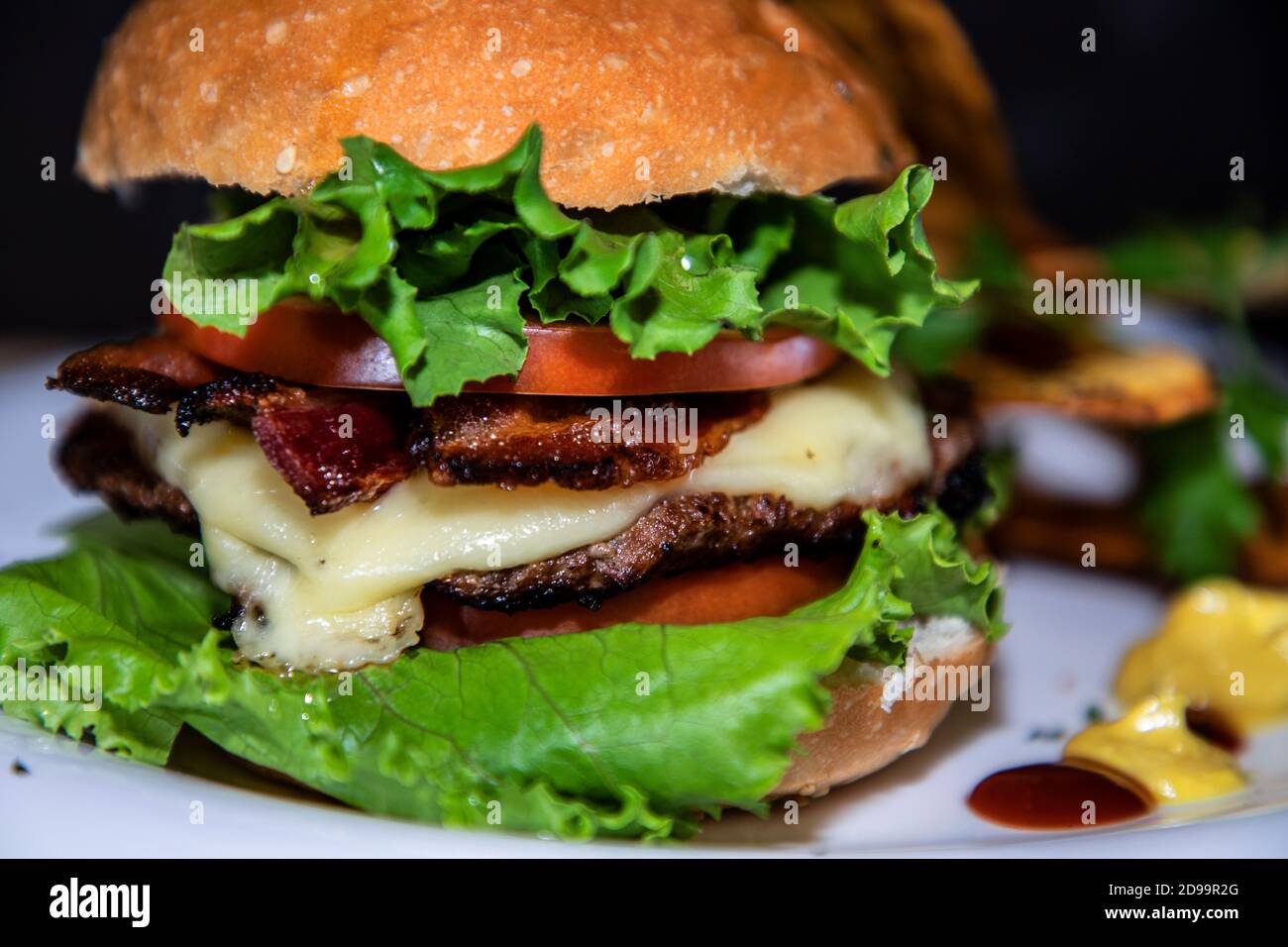 Nahaufnahme eines großen Burgers mit etwas Gemüse Stockfoto