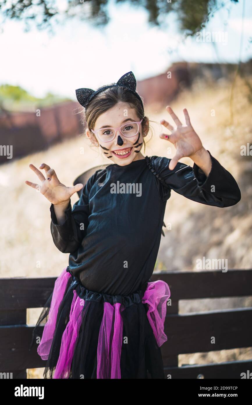 Nettes kleines Mädchen trägt ein Halloween Katze Kostüm lächelnd und  Erschreckt den Fotografen Stockfotografie - Alamy
