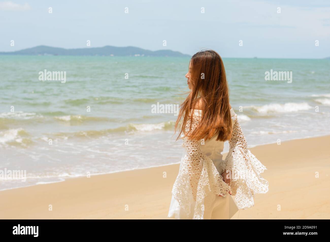 Portrait Frau steht auf Sand Meer im Freien Stockfoto