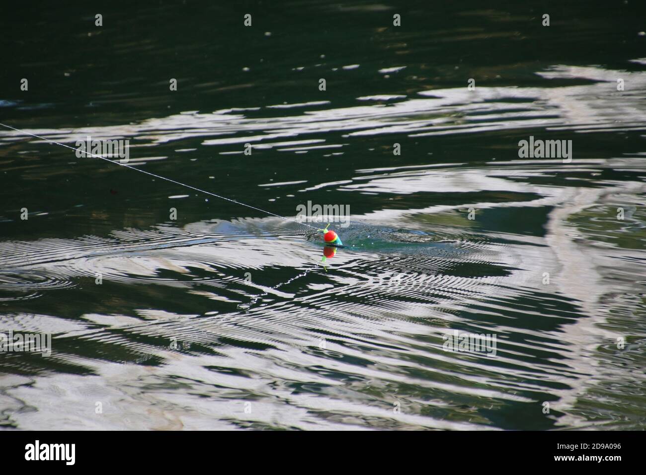 Ein Fischerwagen wird an einem sonnigen Tag mit einer Angelschnur ans Ufer gezogen. Stockfoto