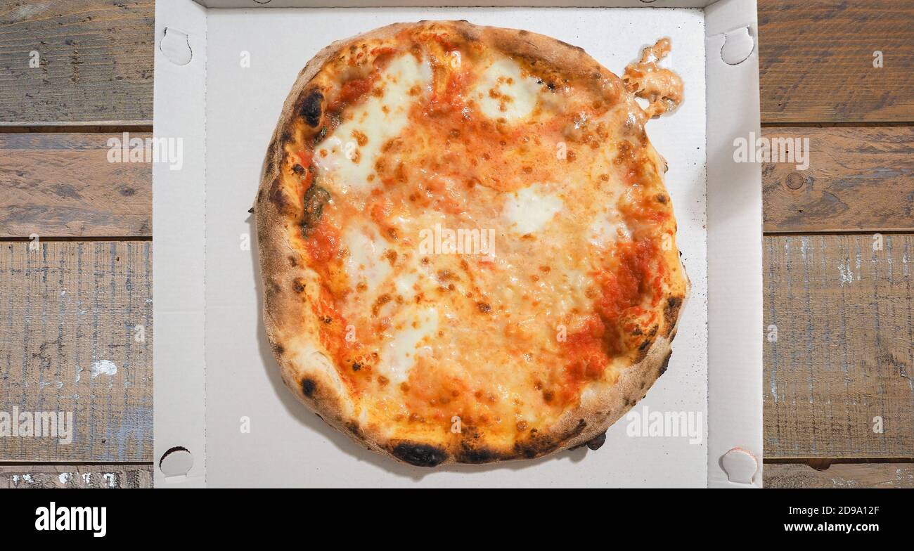 Pizza margherita Karton auf hölzernen Restauranttisch Stockfoto