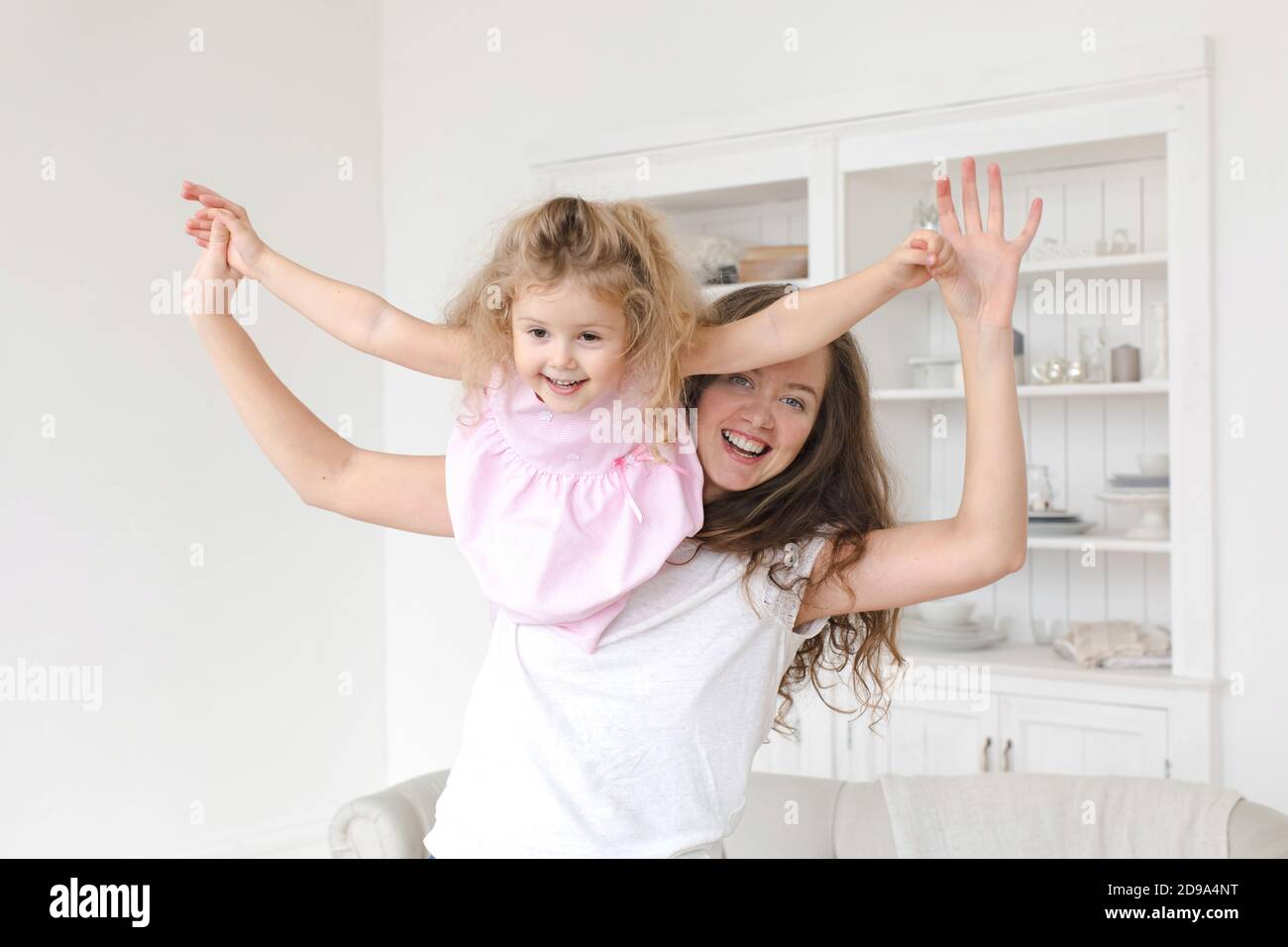 Mutter und Tochter spielen Fliege Traum im Tagesraum Stockfoto