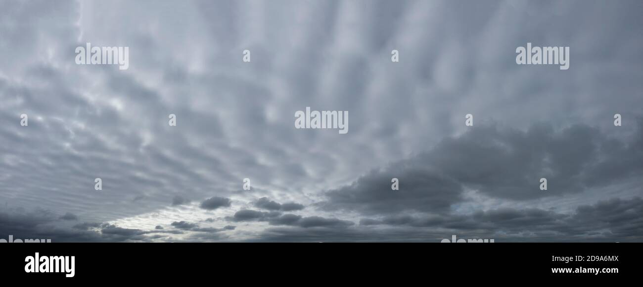 Panorama des grauen dramatischen Himmels mit welligen dicken Wolken. Stockfoto