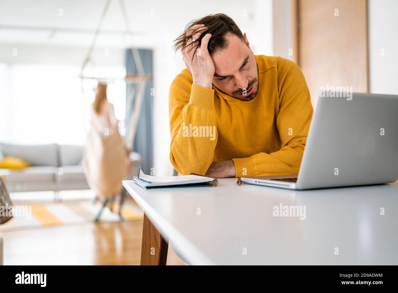 Frustrierter junger Mann, der zu Hause am Laptop arbeitet Stockfoto