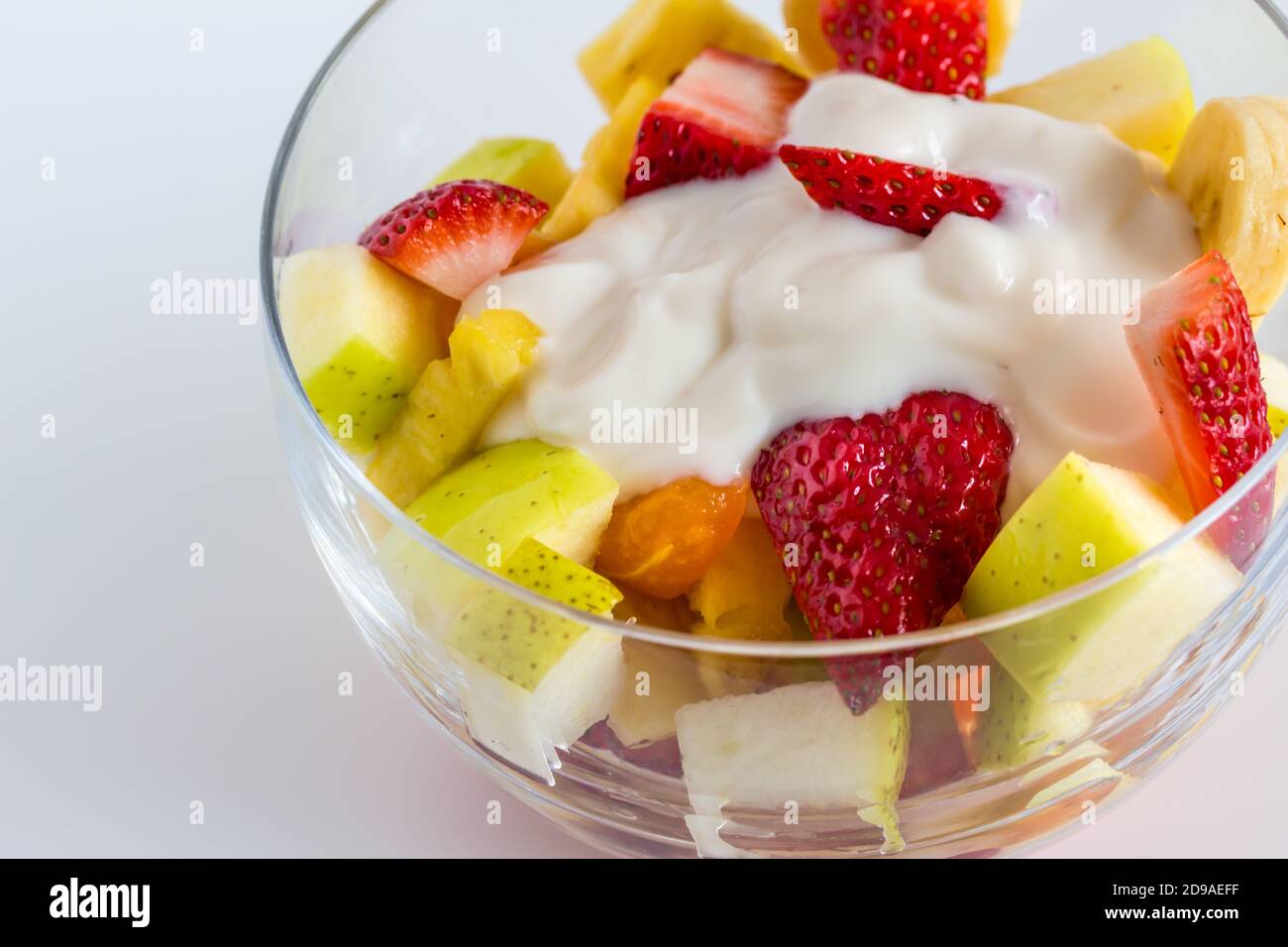 Obstsalat mit Naturjoghurt in Glasschüssel isoliert auf Weißer Hintergrund Stockfoto