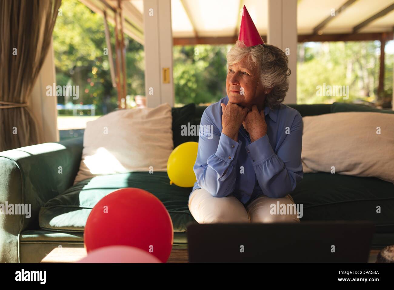 Ältere kaukasische Frau, die Zeit zu Hause verbringt, um einen Geburtstag zu feiern Stockfoto