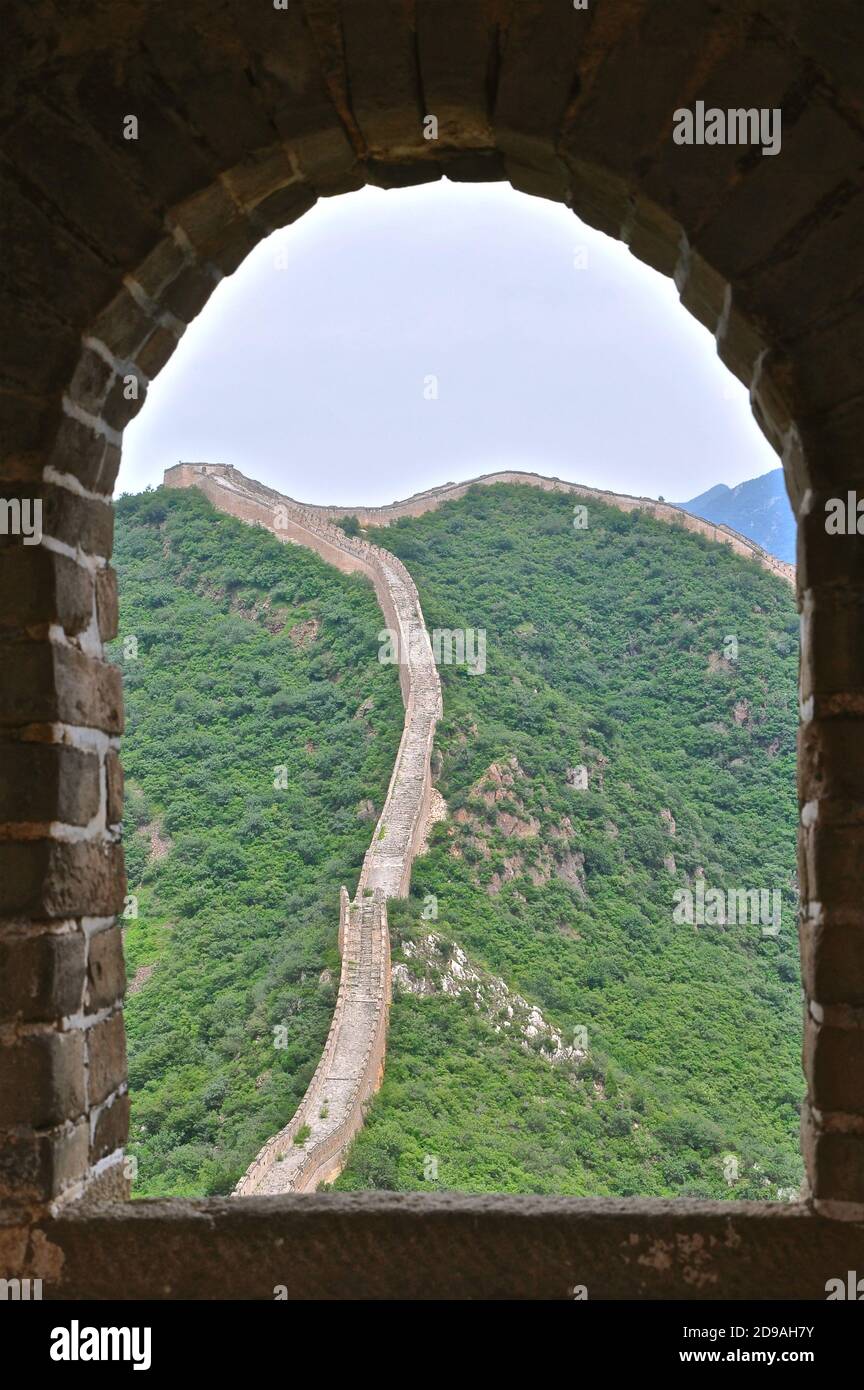 Ein Abschnitt der Chinesischen Mauer durch das Bogenfenster eines der vielen steinernen Aussichtspunkte. Stockfoto