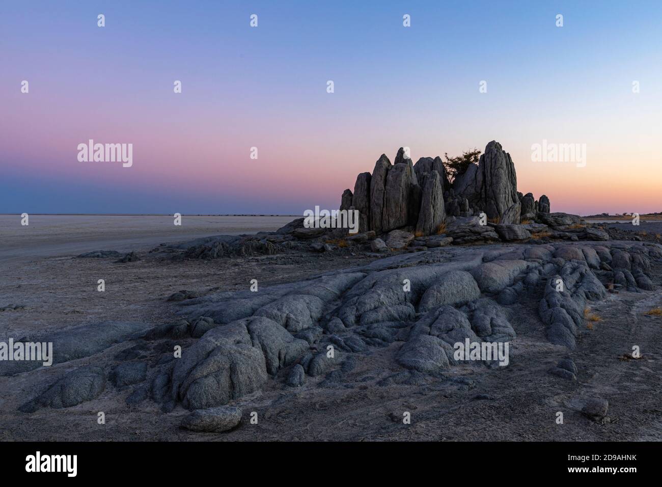 Felsmonolith in rosa und blauen Sonnenuntergangsfarben Stockfoto