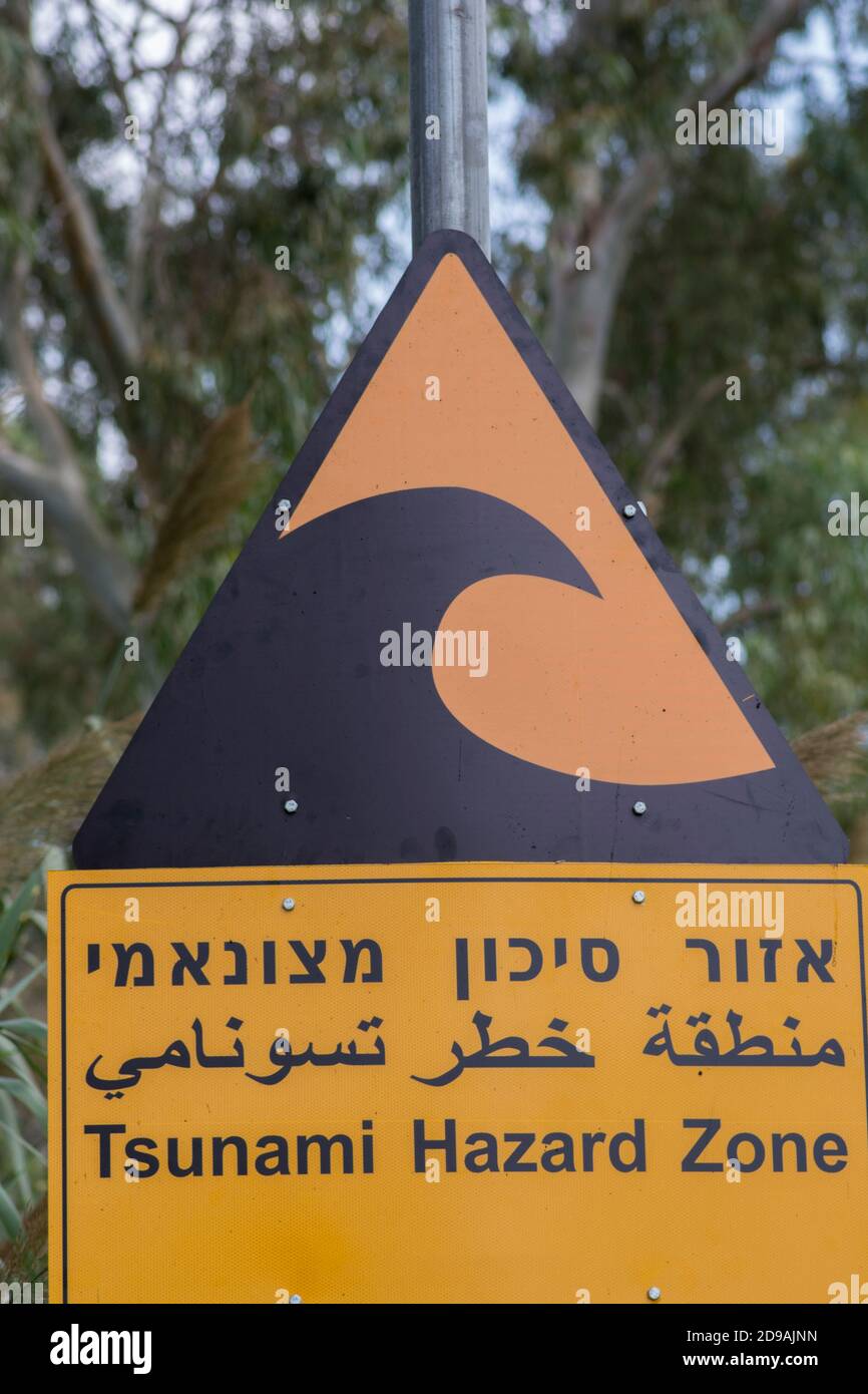 Tsunami-Warnschild mit einer "Tsunami-Gefahrenzone" in Hebräisch, Englisch und Arabisch. Stockfoto
