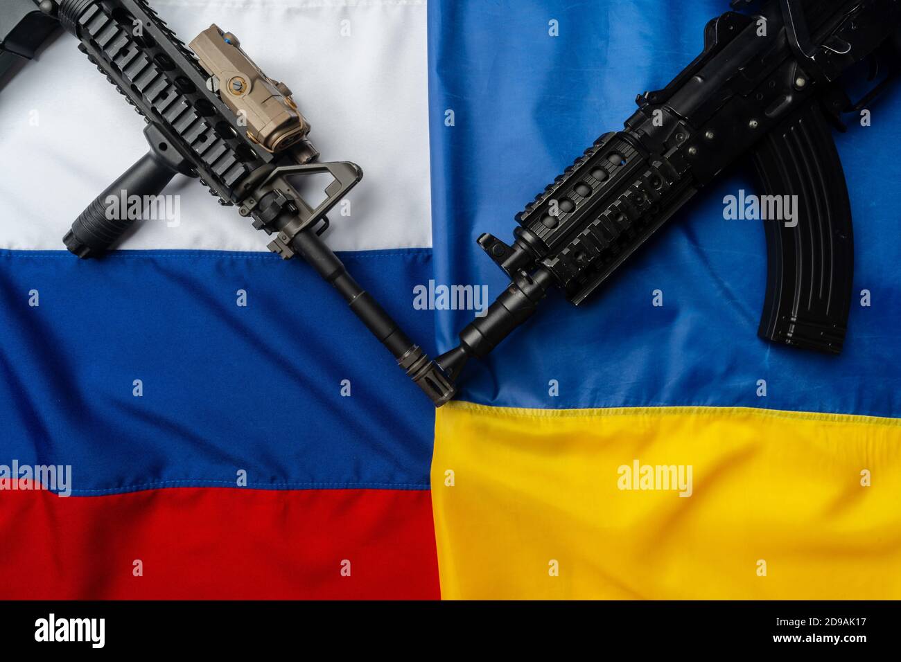 Flaggen von Russland und der Ukraine gefaltet zusammen mit Gewehr Stockfoto