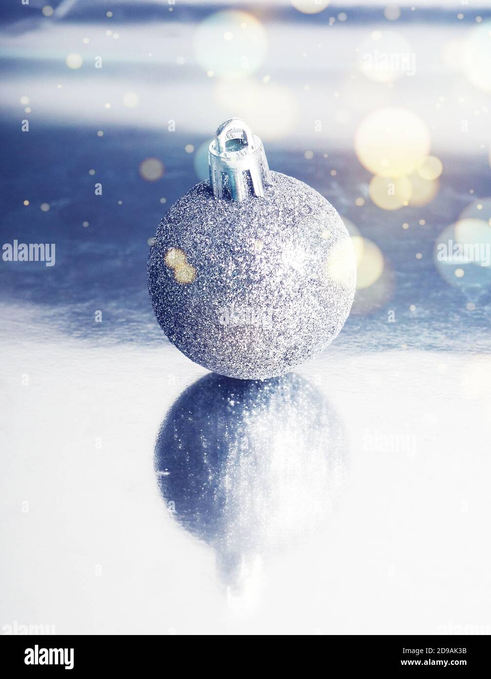 Silberner Ball auf Hintergrund mit Reflexion, Minimalismus Weihnachten. Stockfoto