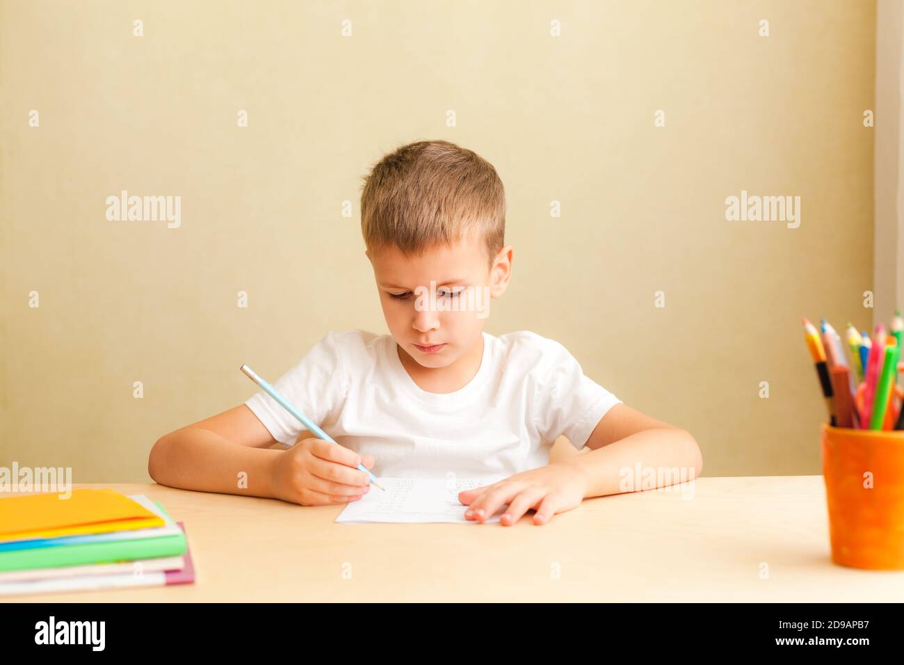 Kopf erschossen Nahaufnahme Porträt von niedlichen kleinen Schüler zu Hause lernen. 7 Jahre alter Junge macht Unterricht am Schreibtisch in seinem Zimmer. Stockfoto