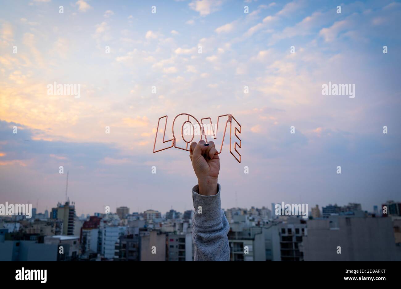 Hand hält LIEBESTEXT gegen den Sonnenuntergang Stockfoto