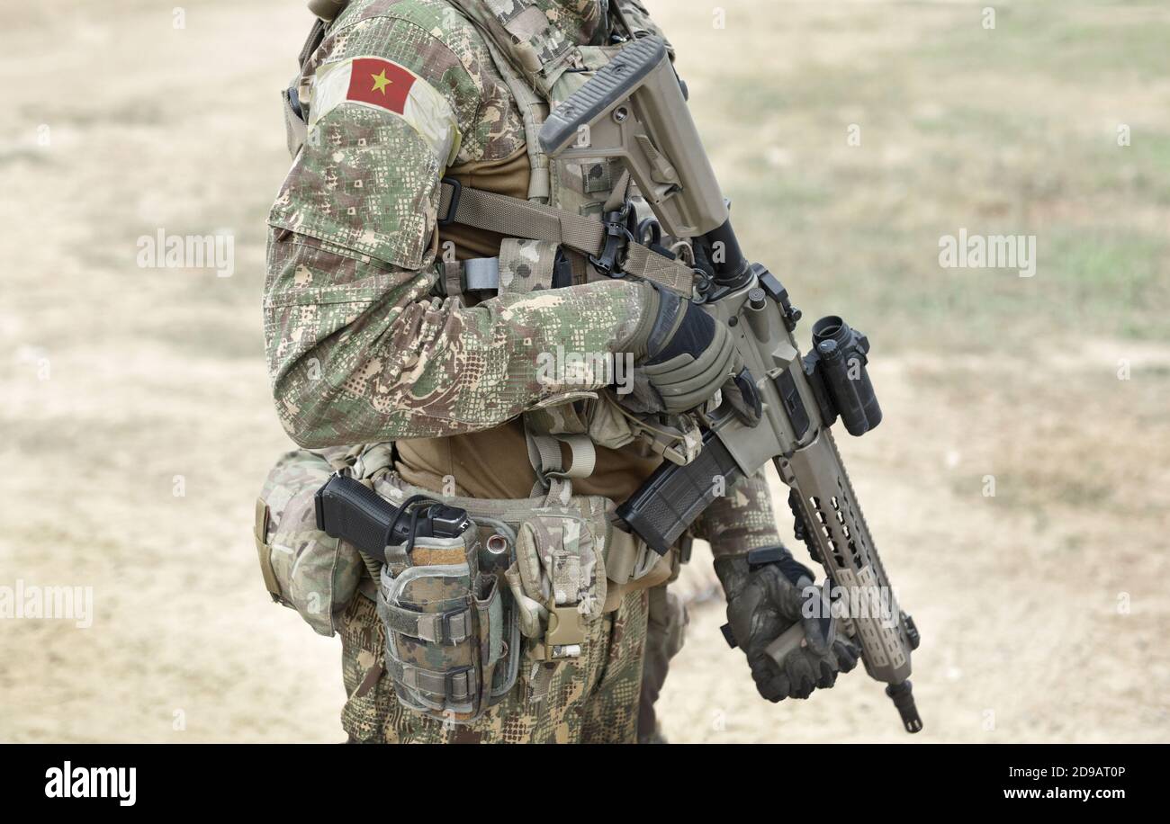 Soldat mit Sturmgewehr und Flagge Vietnams auf Militäruniform. Collage. Stockfoto