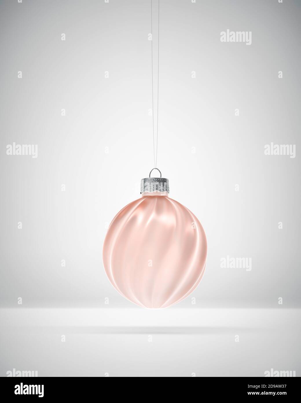 Helle Bronze verdreht gerippte Weihnachtskugel über weißem Hintergrund hängen. Diffuses Licht. Weihnachtsdekoration, festliches Atmosphärenkonzept. Stockfoto