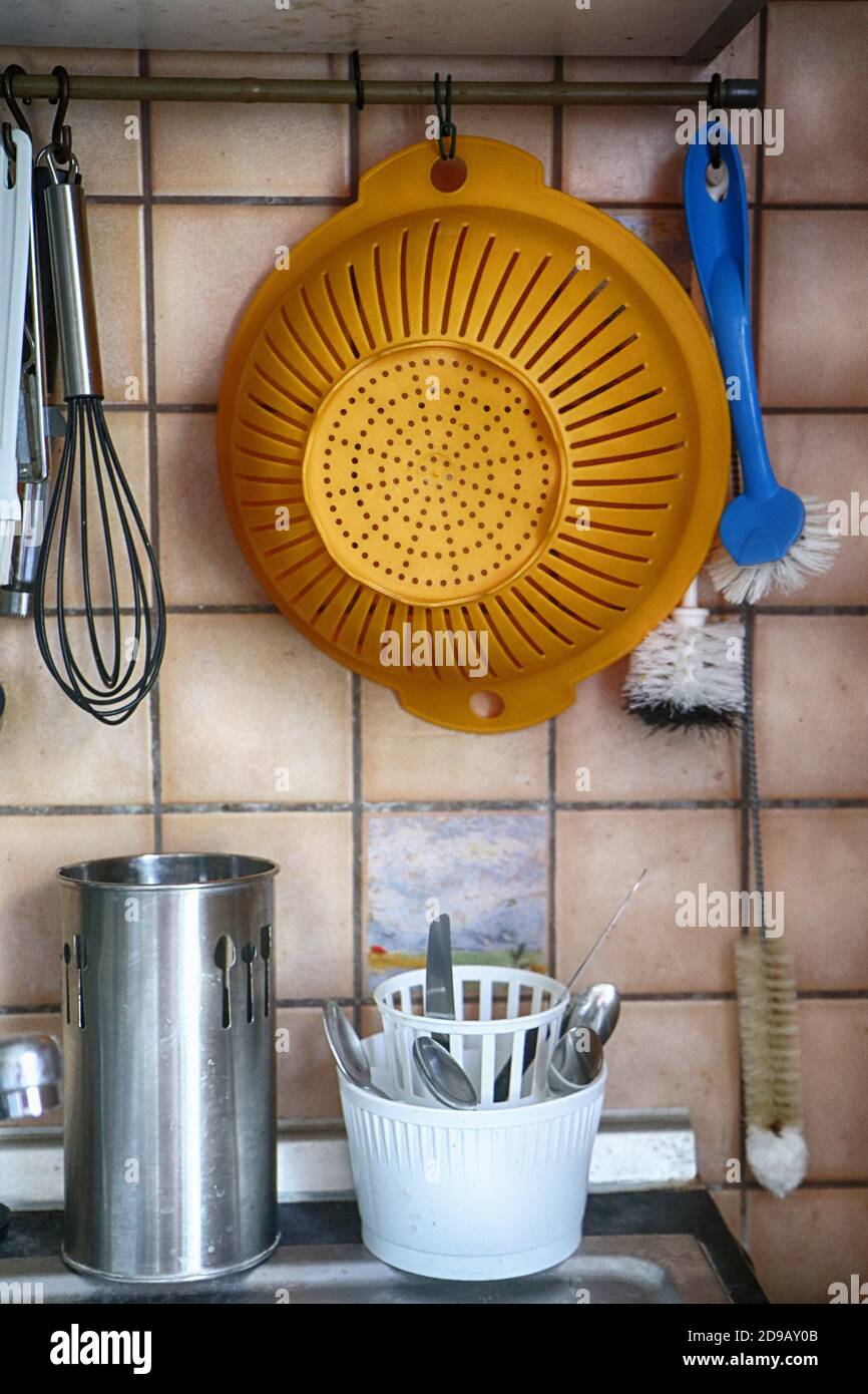 Nützliche Küchenutensilien in der Nähe der Spüle: Sieb, Schneebesen,  Reinigungsbürsten und Besteck Stockfotografie - Alamy