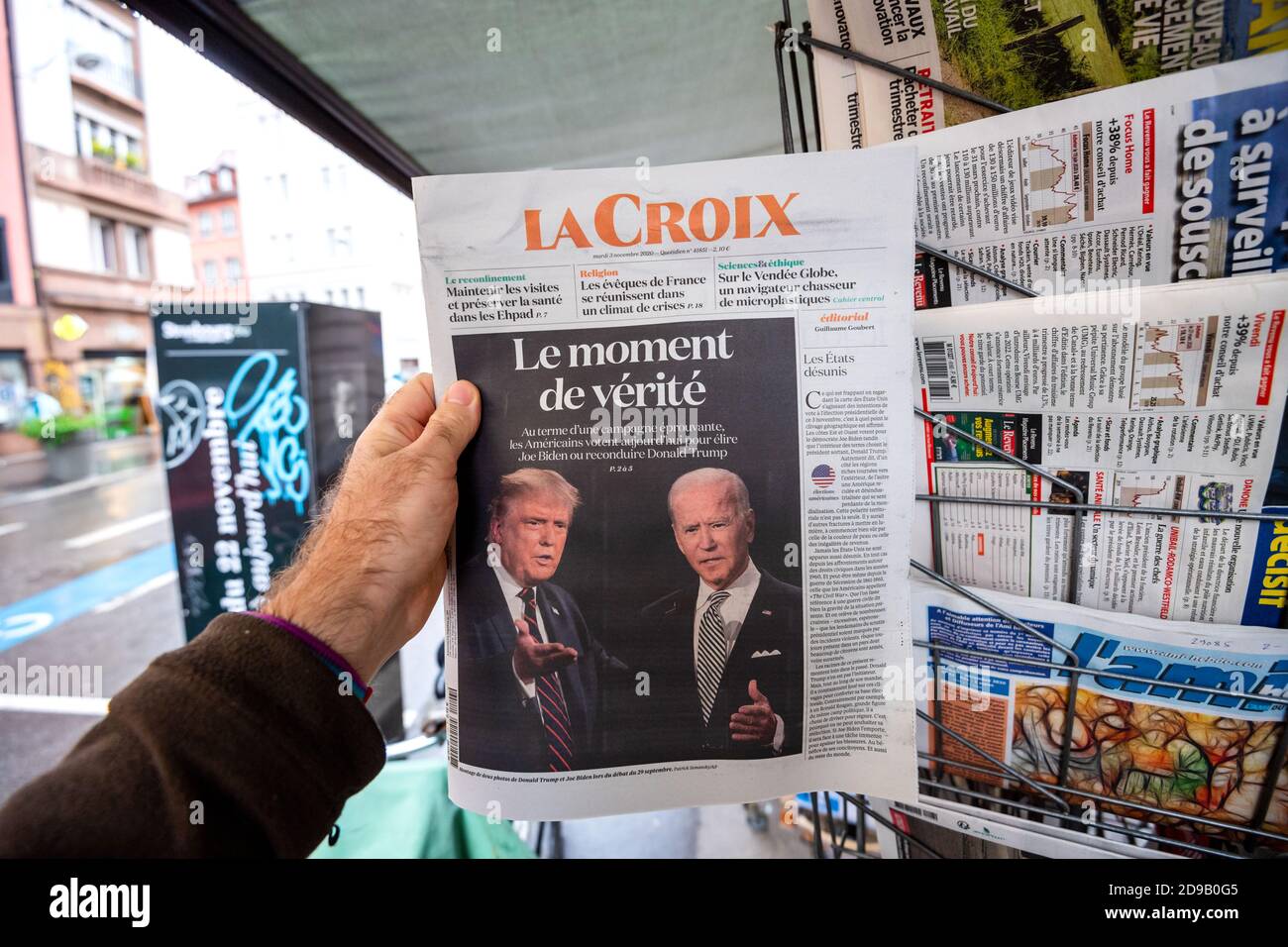 Paris, Frankreich - 3. Nov 2020: POV männliche Hand in der La Croix Zeitung mit Cover mit dem letzten Tag der Wahl für US-Präsident Rennen zwischen Donald Trump und Joe Biden, demokratischer Kandidat Stockfoto