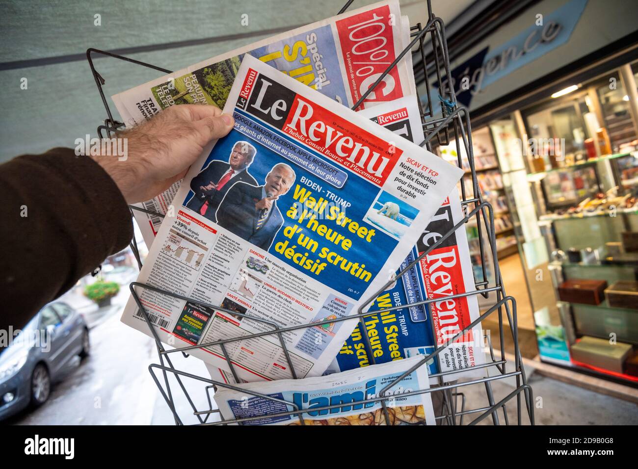 Paris, Frankreich - Nov 3, 2020: POV männliche Hand an der Le Revenu Französisch Zeitung mit Cover mit letzten Tag der Wahl für US-Präsident Rennen zwischen Donald Trump und Joe Biden, demokratischer Kandidat Stockfoto