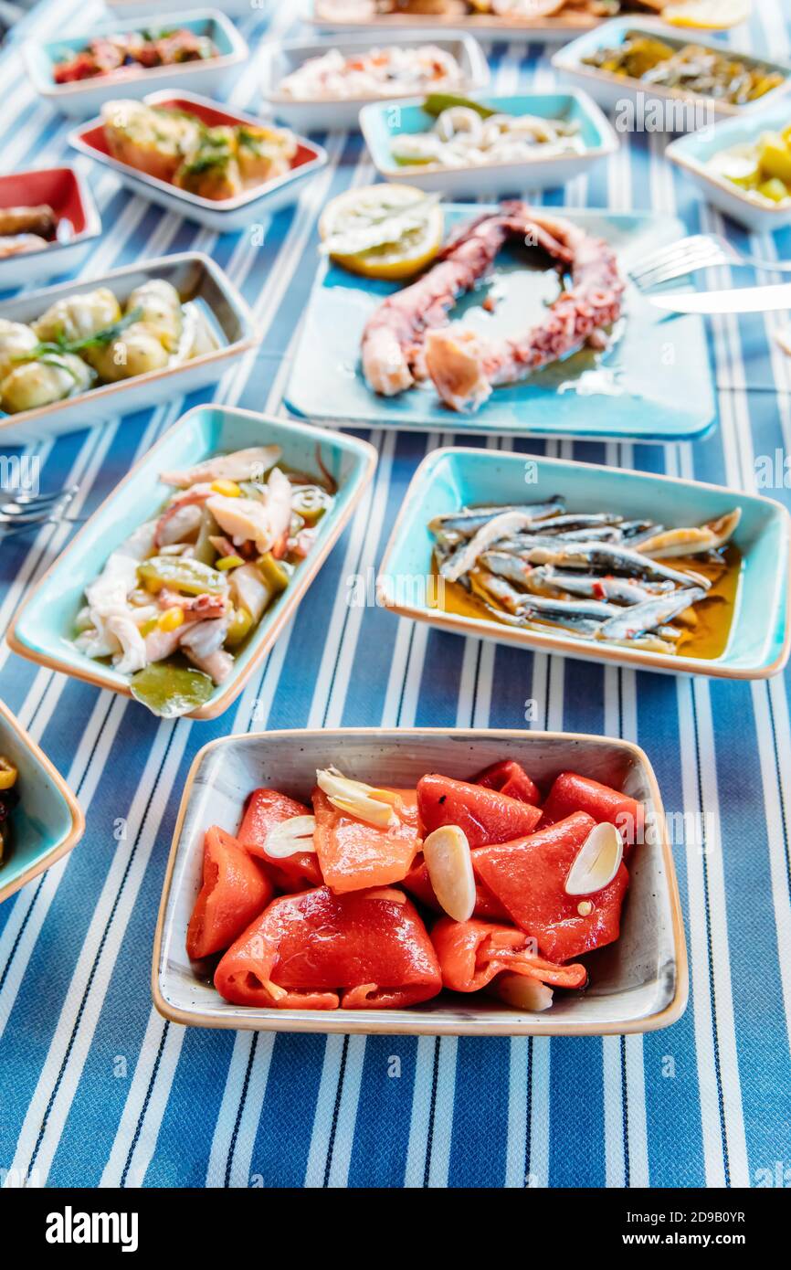 Meeresfrüchte, gegrilltes Fleisch, Meze, Kräuter, Fisch, Raki, Ouzo, Vorspeisen und Salate im griechischen oder türkischen Fischrestaurant auf dem Tisch zum Abendessen oder Mittagessen Stockfoto