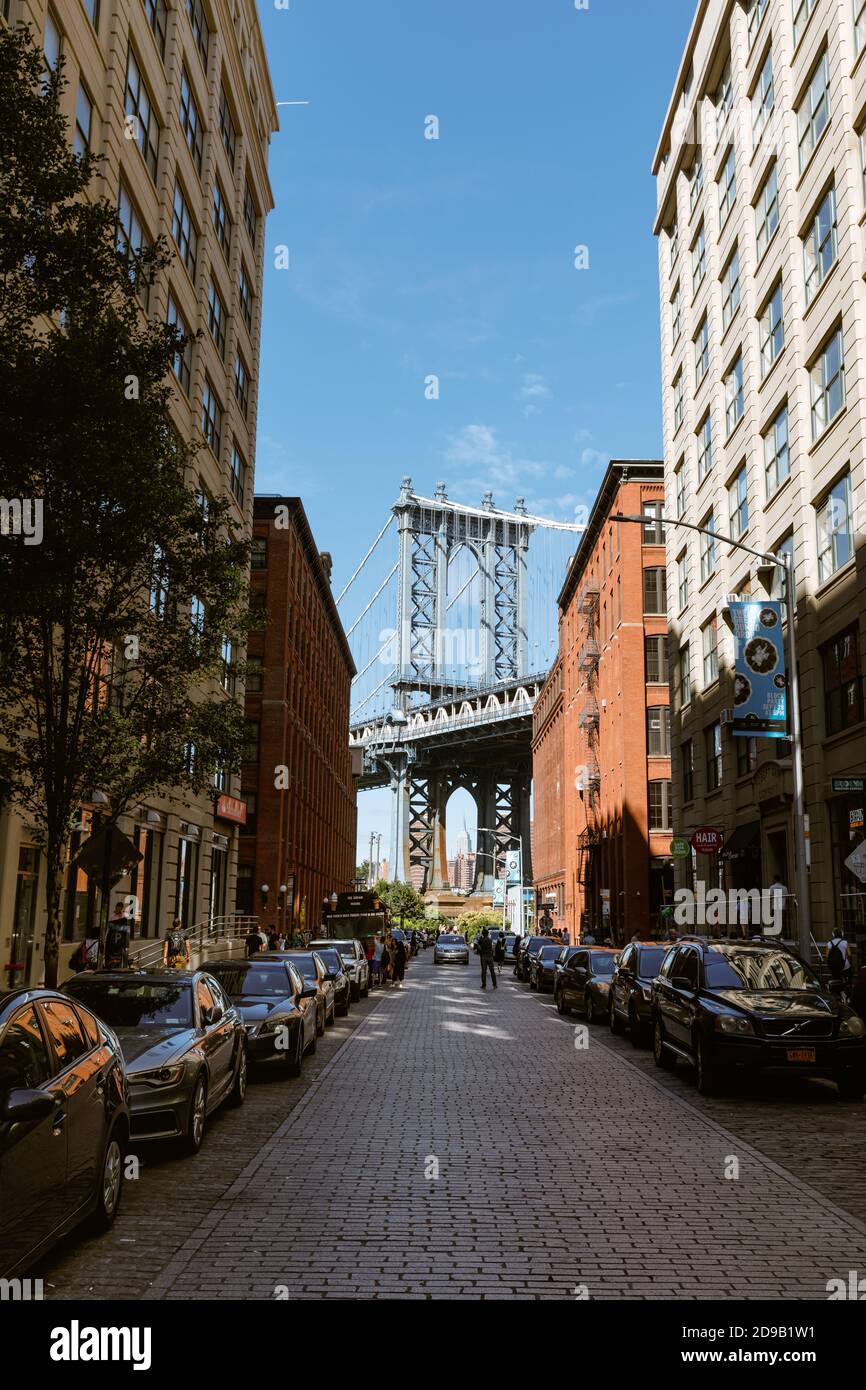 NEW YORK, USA - 22. Sep 2017: Manhattan Bridge mit dem Empire State Building und Backsteinmauern aus Dumbo, Brooklyn Stockfoto