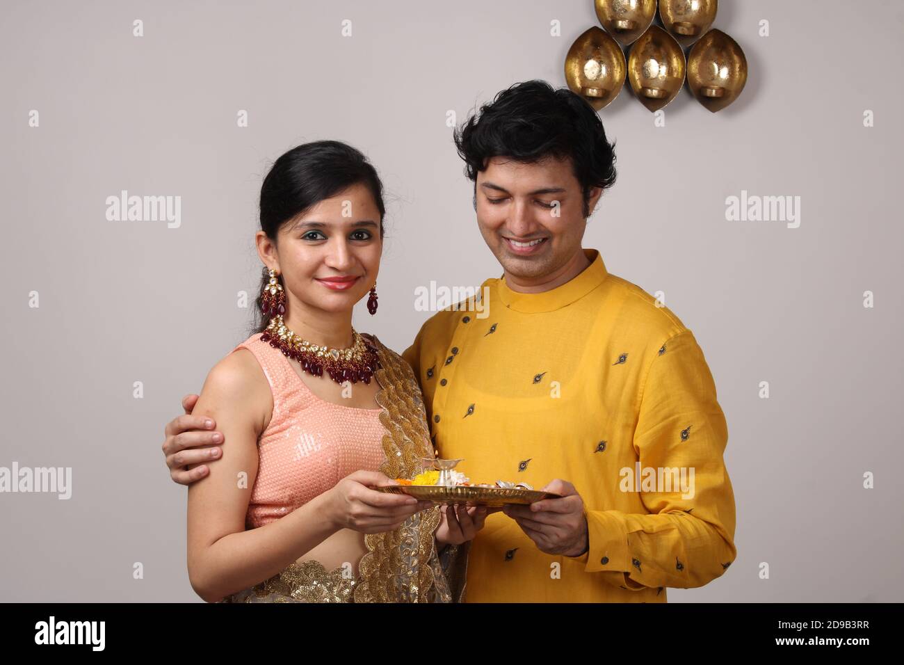 Nettes Paar hält Puja thali. Stockfoto