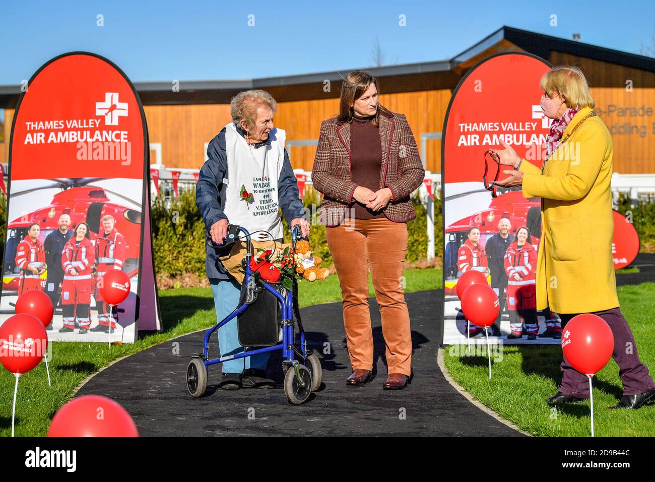 Die 104-jährige Ruth Saunders wird von Ratsmitglied Elizabeth O'Keeffe, rechts, über Ruths Tochter Kate Saunders, Mitte, eine Medaille überreicht, nachdem Ruth ihre Ziellinie auf der Newbury Racecourse in Berkshire überquert hat, um Geld für Thames Valley Air Ambulance zu sammeln. Ruth machte sich ursprünglich auf den Weg, 104 Runden ihres Blocks zu laufen, um ihrem Alter, einer Strecke von etwa 21 Meilen, zu entsprechen, entschied sich aber, ihr Ziel auf einen vollen Marathon (26.2 Meilen) auszudehnen, nachdem sie von ihrer Familie ermutigt wurde. Stockfoto