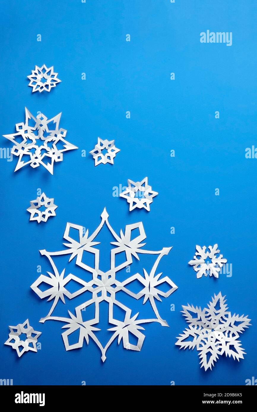Komposition mit weißen Papier Schneeflocken auf blauem Hintergrund Stockfoto