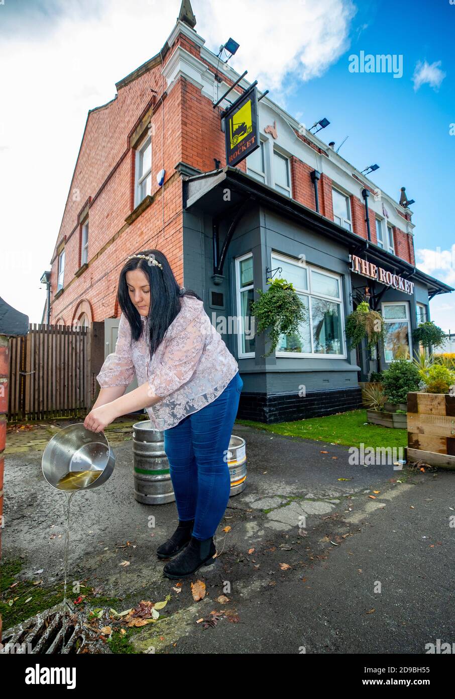 Laura Martindale, Managerin des Rocket Public House in Whiston, gießt das verwöhnte Bier weg, das nach der Platzierung des Pubs in Rang drei abgegangen ist und nun vor einer vier-Wochen-Sperre für England vom Donnerstag steht. Stockfoto