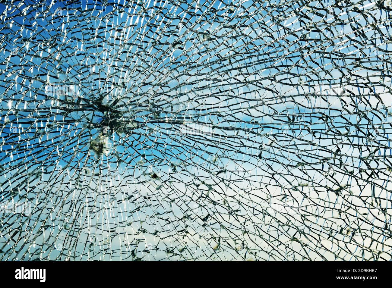 Gebrochenes Fenster aus Sicherheitslaminatglas nach einem Steinwurf, zeigt ein charakteristisches kreisförmiges Spinnennetz Muster und körnige Brocken, Schutz A Stockfoto