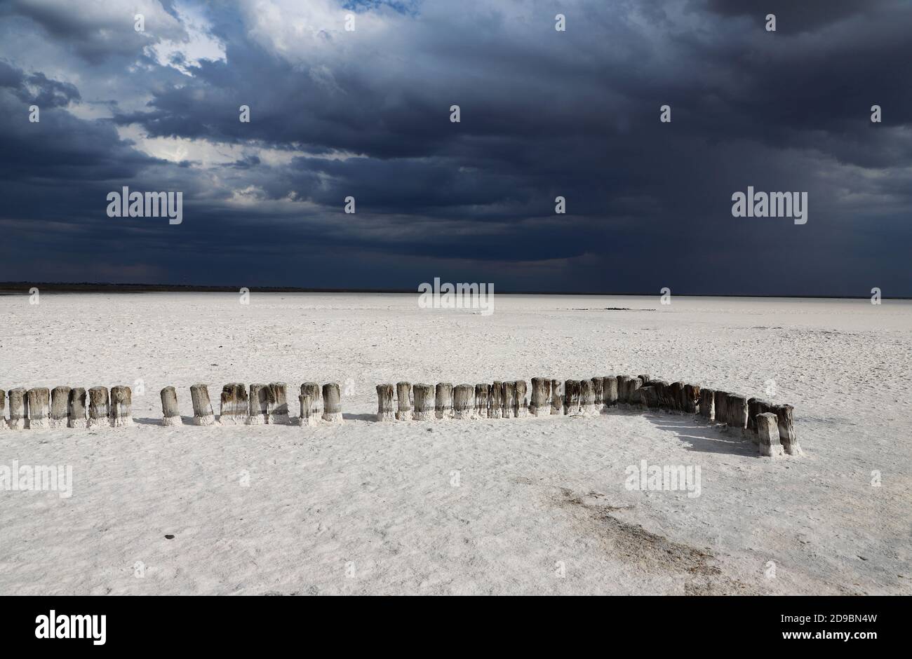 Salzsee oder Wüste nach Regen, dunkle und weiße Wolken am Himmel. Stockfoto