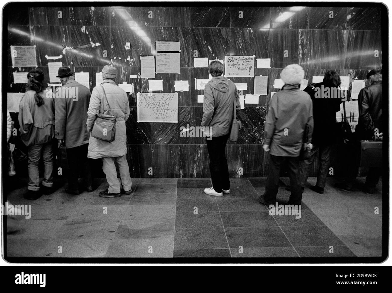 Tschechoslowakei Samtene Revolution Prag November 1989 gescannt in 2020 Einwohner Lesung Samizdat Plakate in Prag während der Samtenen Revolution. Wikipedia: Die Samtene Revolution (tschechisch: Sametová revolutionce) oder sanfte Revolution (slowakisch: nežná revolúcia) war ein gewaltfreier Machtwechsel in der damaligen Tschechoslowakei, der vom 17. November auf den 29. Dezember 1989 stattfand. Zu den Volksdemonstrationen gegen die Einparteienregierung der Kommunistischen Partei der Tschechoslowakei gehörten Studenten und ältere Dissidenten. Das Ergebnis war das Ende von 41 Jahren Einparteienherrschaft in der Tschechoslowakei, und die anschließende d Stockfoto