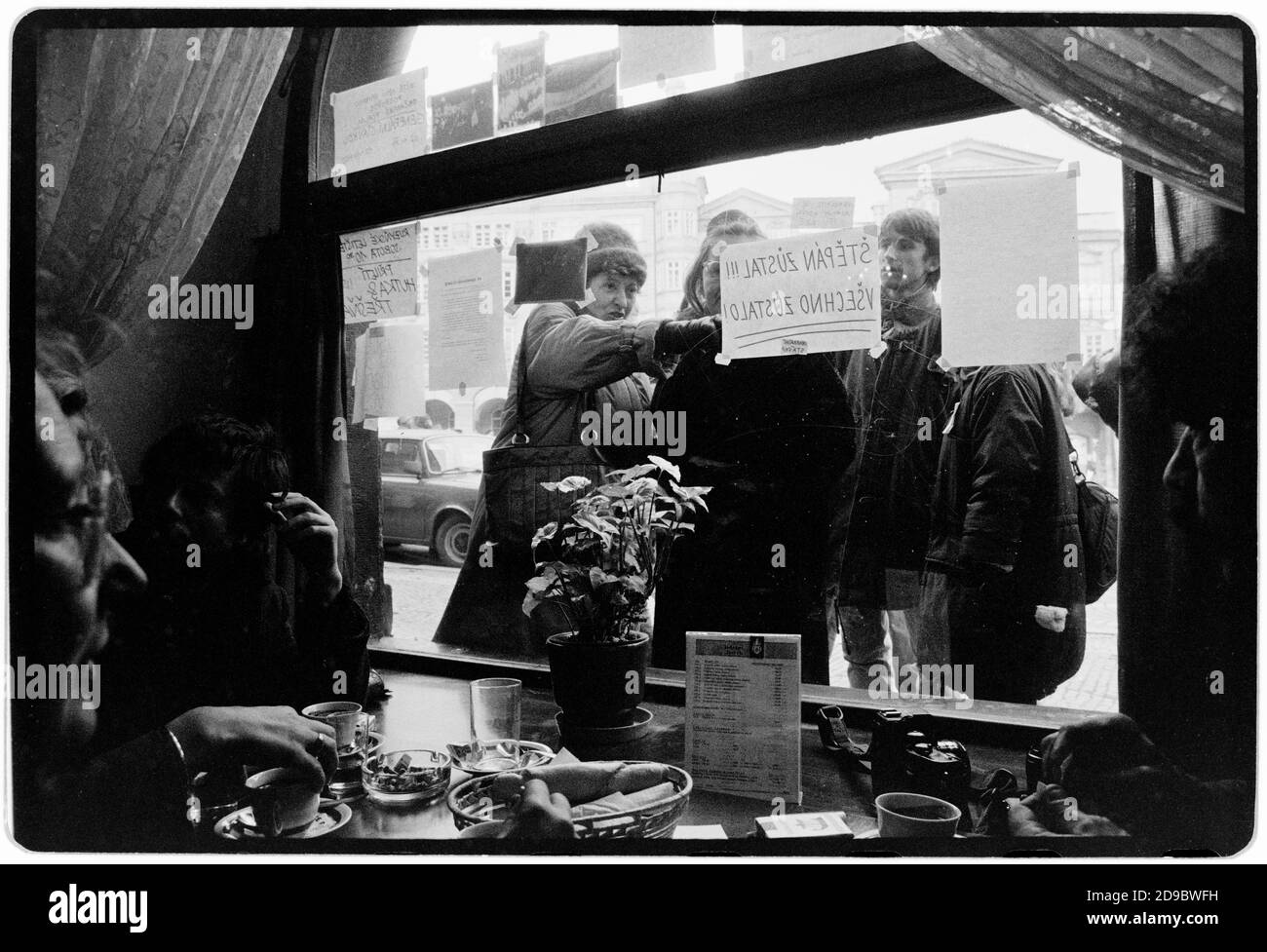 Tschechoslowakei Samtene Revolution Prag November 1989 gescannt in 2020 Einwohner Lesung Samizdat Plakate in Prag während der Samtenen Revolution. Wikipedia: Die Samtene Revolution (tschechisch: Sametová revolutionce) oder sanfte Revolution (slowakisch: nežná revolúcia) war ein gewaltfreier Machtwechsel in der damaligen Tschechoslowakei, der vom 17. November auf den 29. Dezember 1989 stattfand. Zu den Volksdemonstrationen gegen die Einparteienregierung der Kommunistischen Partei der Tschechoslowakei gehörten Studenten und ältere Dissidenten. Das Ergebnis war das Ende von 41 Jahren Einparteienherrschaft in der Tschechoslowakei, und die anschließende d Stockfoto