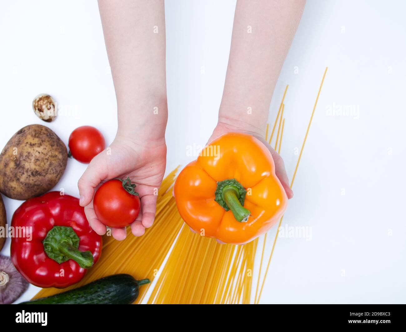 Kinderhände halten frisches Gemüse in der Hand. Konzept der gesunden Ernährung für Kinder. Frisches Gemüse auf weißem Hintergrund Stockfoto