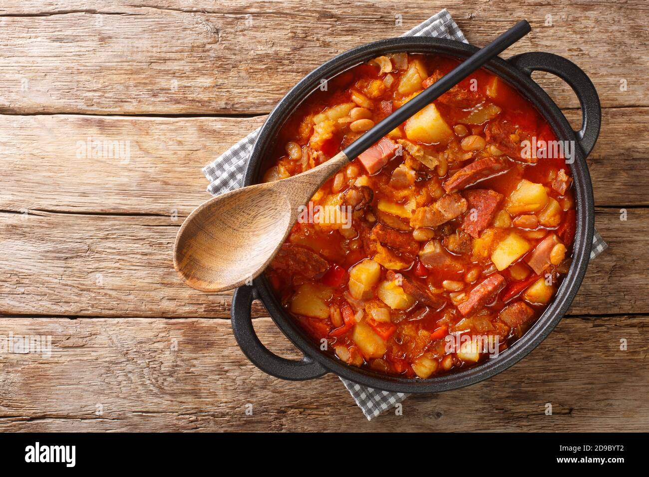 Locro Eintopf von Kürbis, Bohnen, Mais, Kartoffeln, Würstchen und Fleisch in einem Topf auf dem Tisch. Horizontale Ansicht von oben Stockfoto