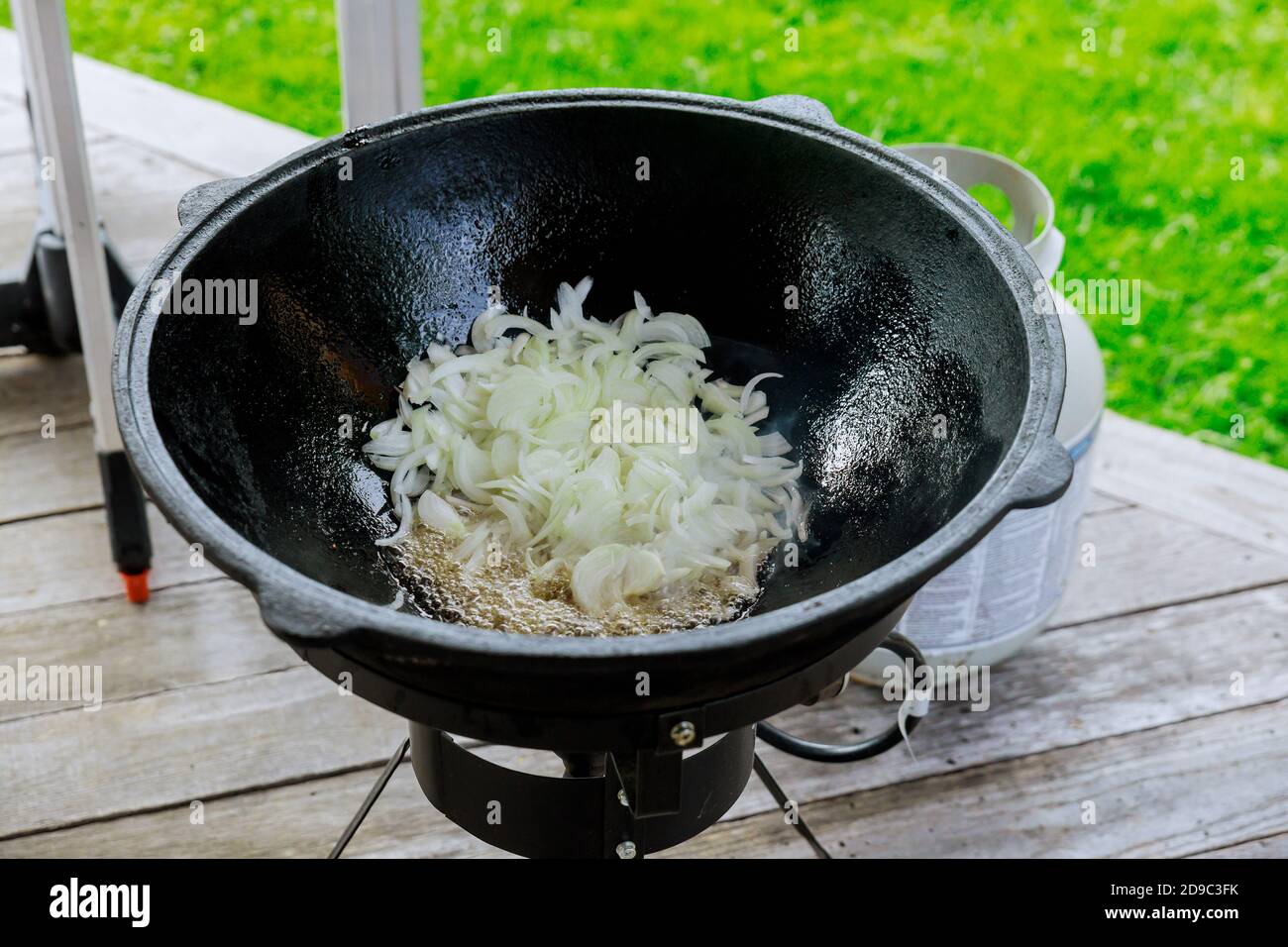 Nahaufnahme eines Eisenkessels mit gebratener Zwiebel für Pilaf. Im Freien. Stockfoto