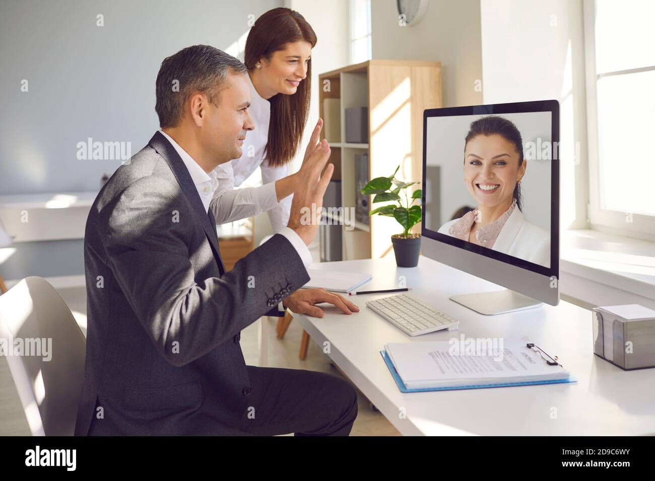 Mitarbeiter nehmen an einer virtuellen Konferenz mit einem Vorgesetzten Teil, der ihre Geschäfte Remote führt. Stockfoto