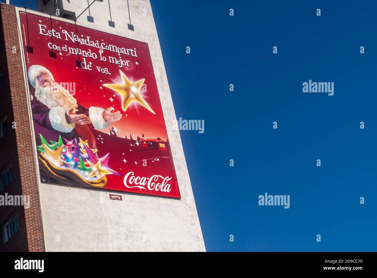 Montevideo, Uruguay- 18. Dezember 2008: Nahaufnahme des roten Coca-Cola weihnachtsbanners an der weißen Wand und flankiert von tiefblauem Himmel. Weihnachtsmann und gol Stockfoto