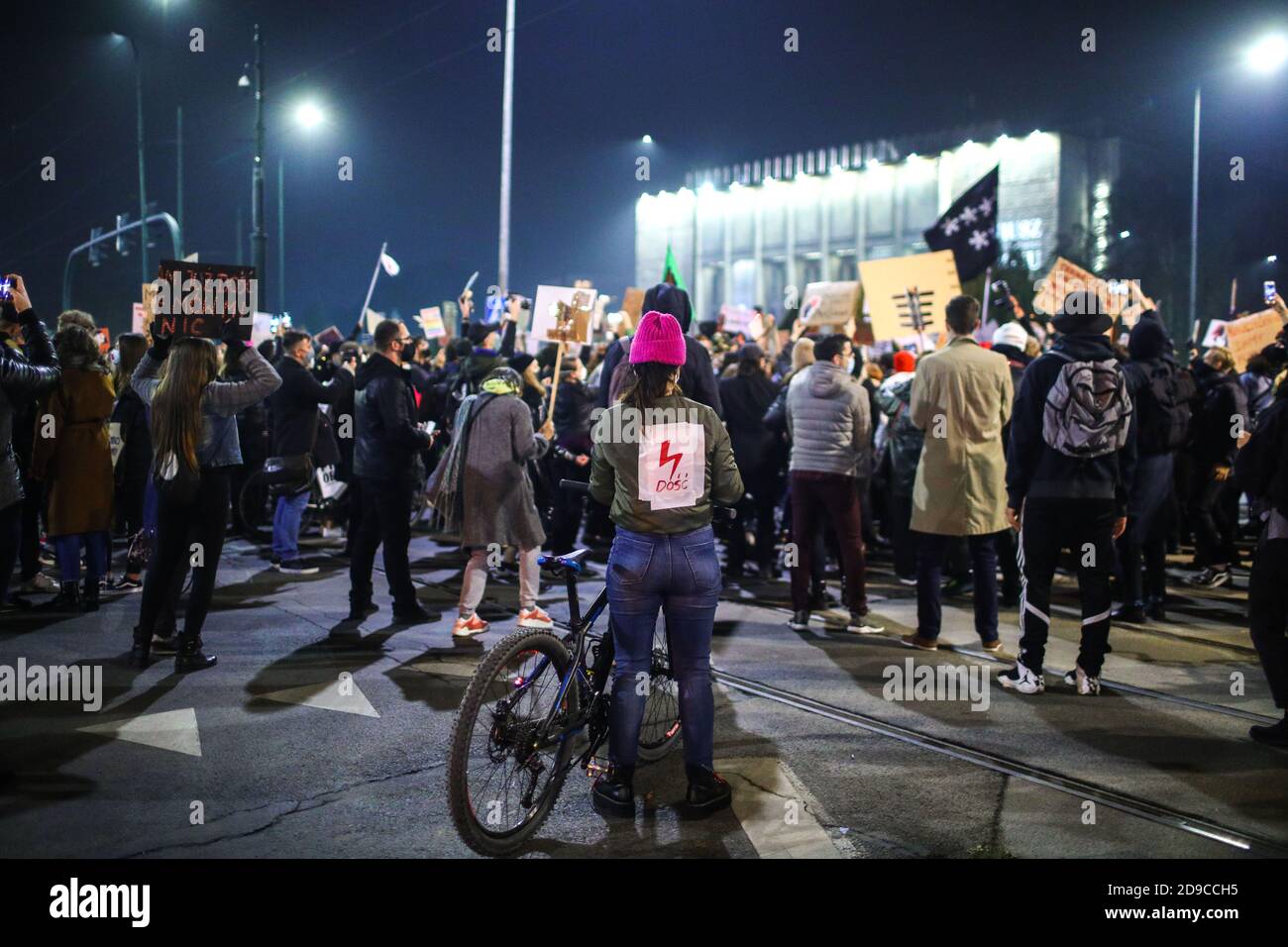 Eine Protesterin mit roter Beleuchtung, ein Symbol von Women Strike auf dem Rücken. Das polnische Verfassungsgericht in seinem neuen, politisch gewählten Gerichtsgebäude rul Stockfoto