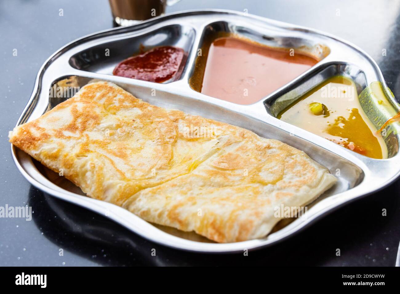Roti prata oder Canai Set mit Curry, Dhal und Sambal Stockfoto