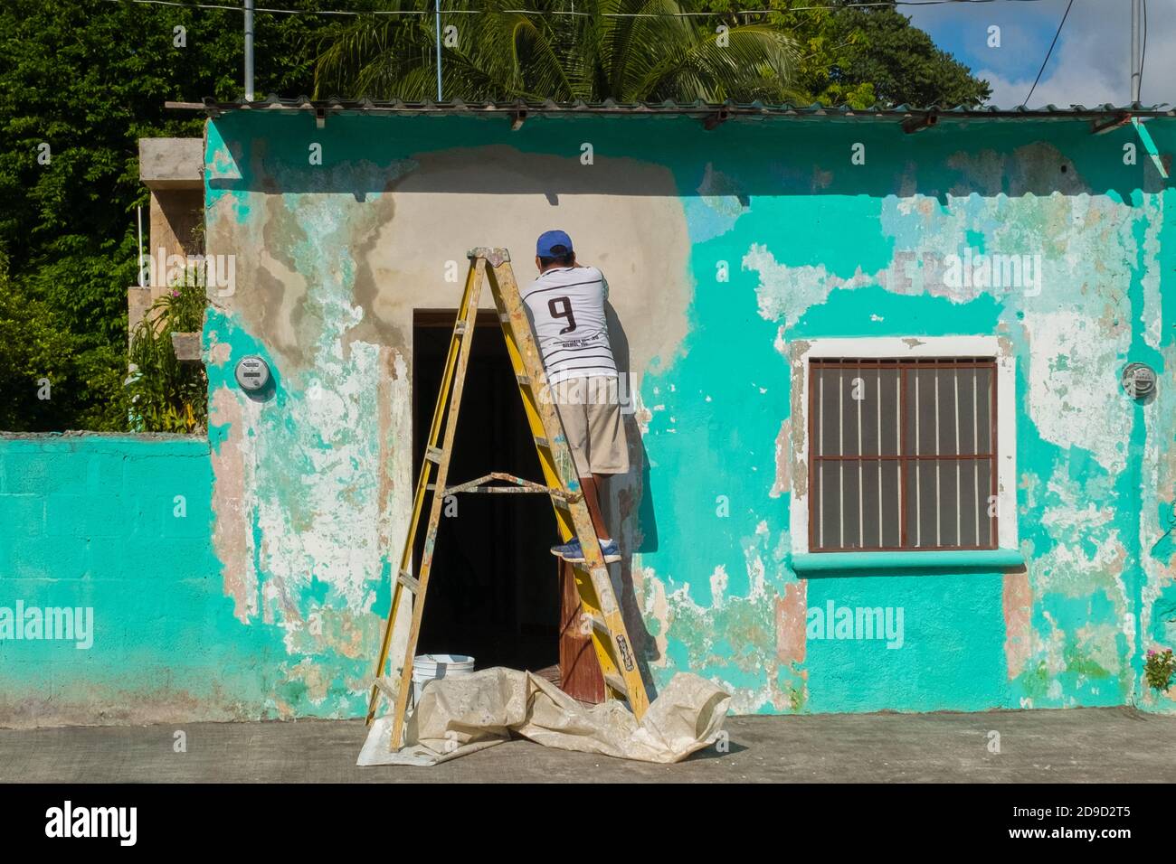 Alltag, Mann, der ein Haus malt, Stadt Telchac, Yucatan, Mexiko Stockfoto