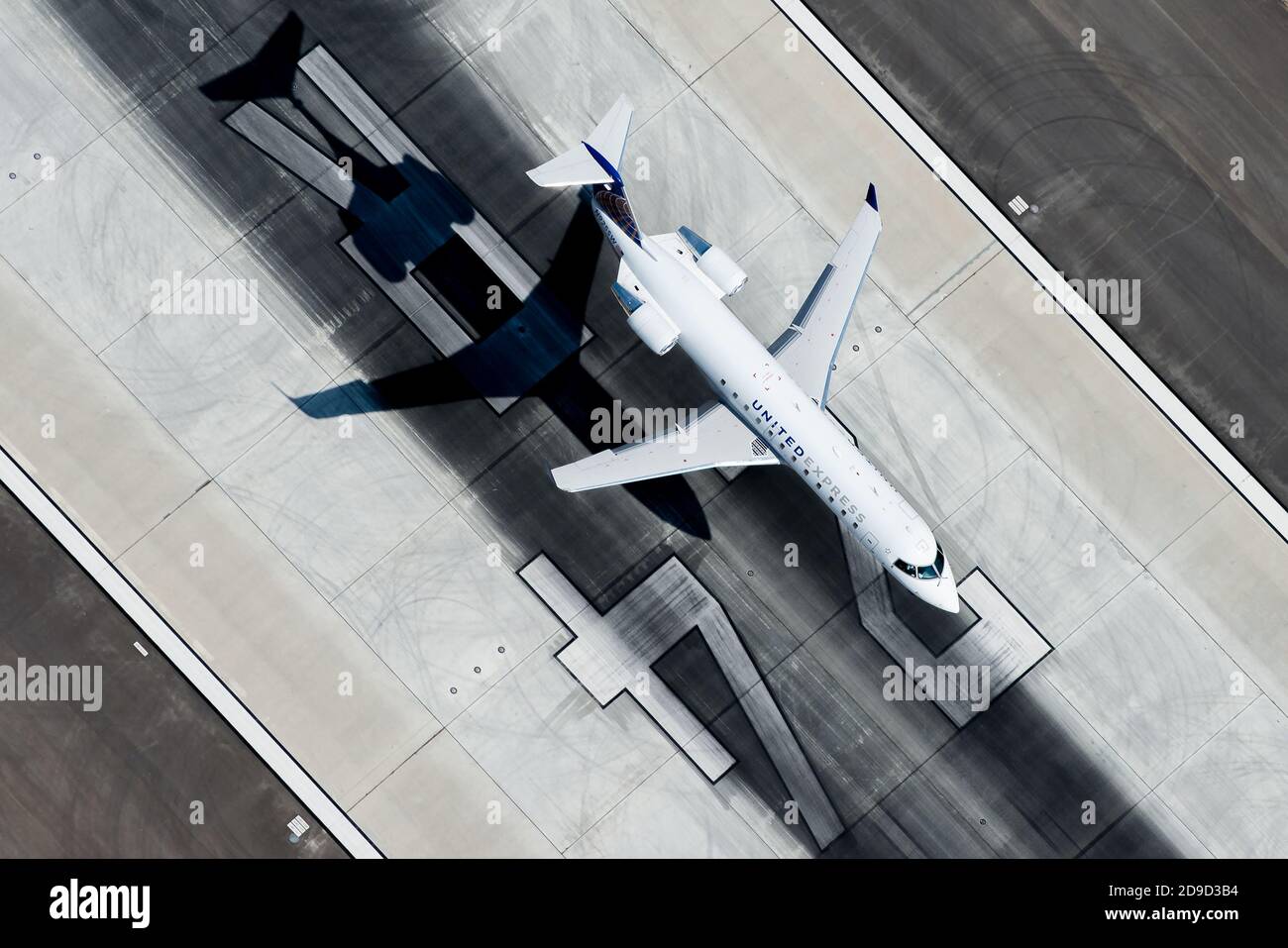 United Airlines (Sky Express) Bombardier CRJ 200 landet am Flughafen Los Angeles. United Express Flugzeug Luftbild mit Runway 24R Marken hinter. Stockfoto