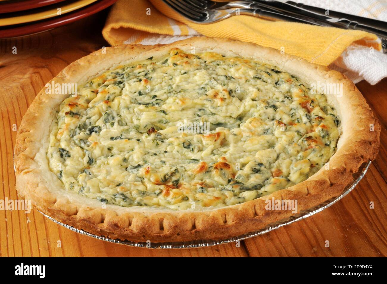 Frische Aufläufe Spinat-Quiche auf einem rustikalen Holztisch Stockfoto