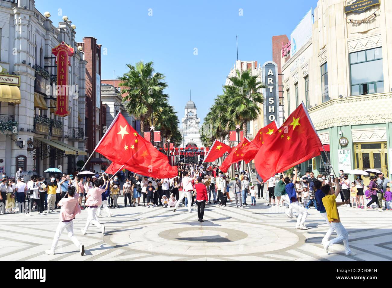 Menschen halten chinesische Flaggen auf der Welt des Films der Brüder Huayi in Suzhou, der ostchinesischen Provinz Jiangsu, 2. Oktober 2020. Stockfoto
